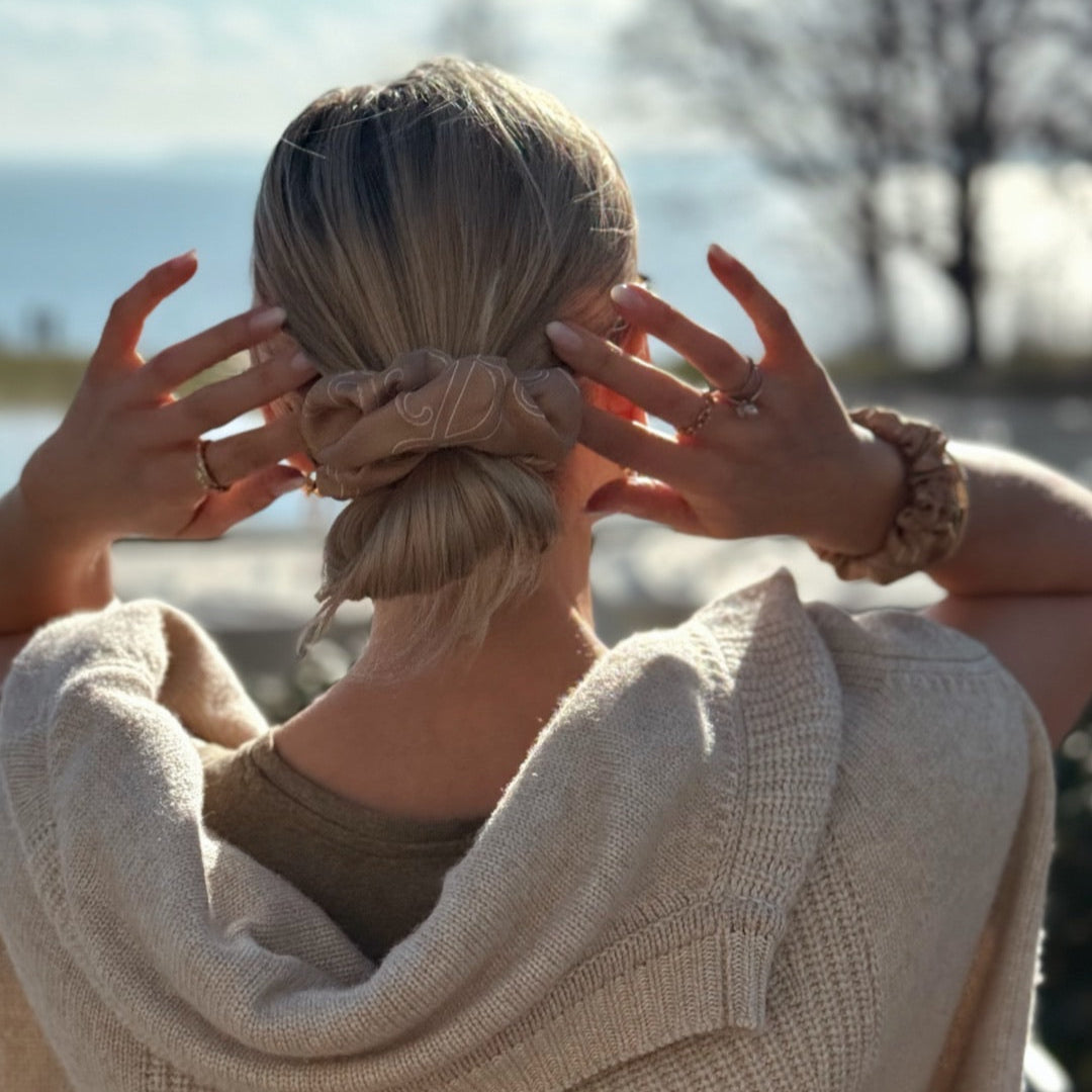 Sirocco-brun SILK& maxi scrunchie i silke med logomønster omkring en lav hårknold