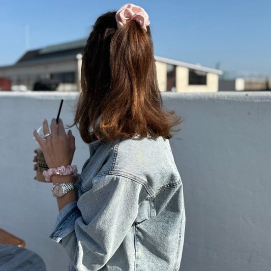 SILK& Scrunchie Maxi in rose pink, made from 100% Italian silk, worn in a ponytail and on the wrist.